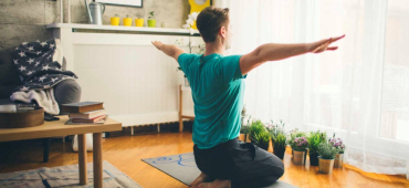 Man tränar hemma på yogamatta